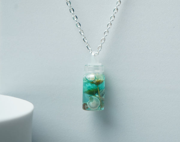 Seashell and flower in small bottle pendent