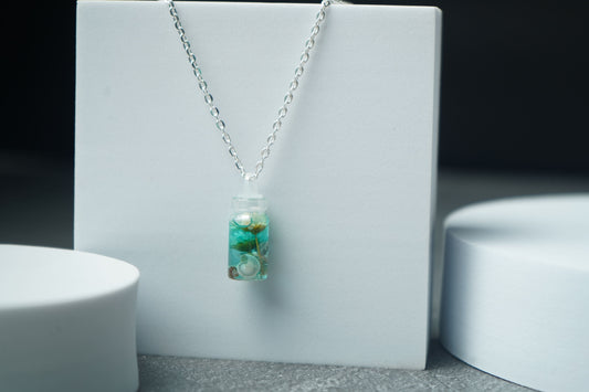 Seashell and flower in small bottle pendent