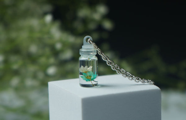 Small flower in small bottle pendent